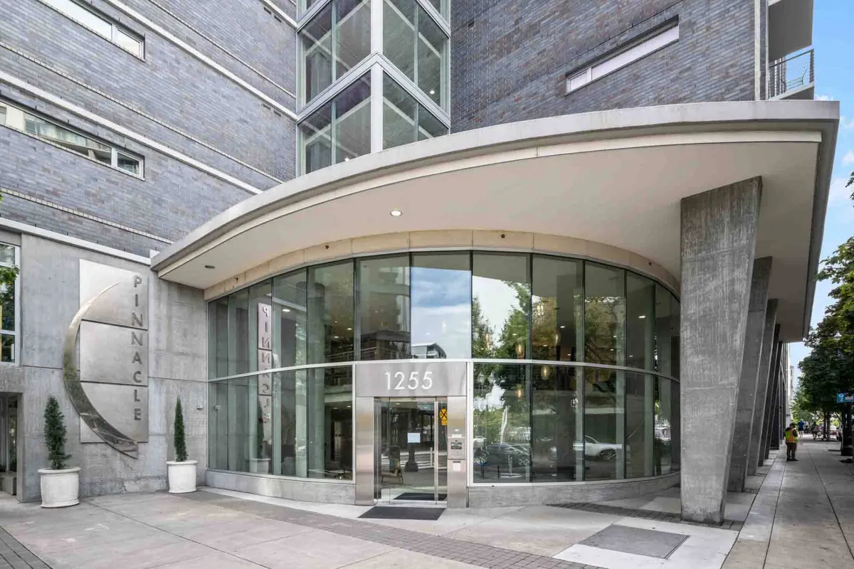 This image captures the building’s entrance with a modern glass façade, prominently displaying the Pinnacle sign and a curved awning. The setting hints at the secure and upscale nature of the building, making a strong first impression for arriving residents and guests.